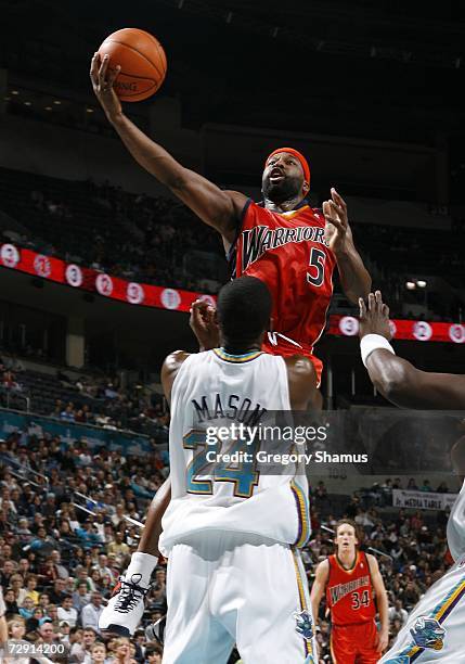 Baron Davis of the Golden State Warriors goes up for a shot over Desmond Mason of the New Orleans/Oklahoma City Hornets in NBA action January 2, 2007...