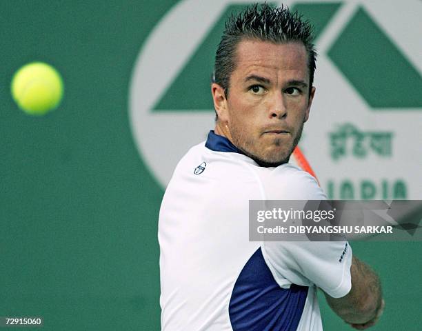 Tennis player Xavier Malisse of Belgium plays a return to his Italian opponent Stefano Galvani during their second round match in the Chennai Open...