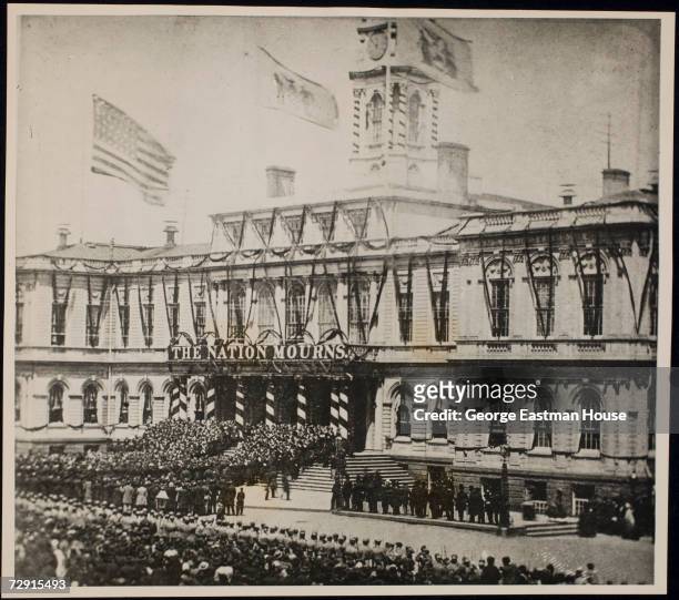 View of American President Abraham Lincoln's funeral procession as it arrives at City Hall, New York, New York, April 25, 1865. A banner above the...