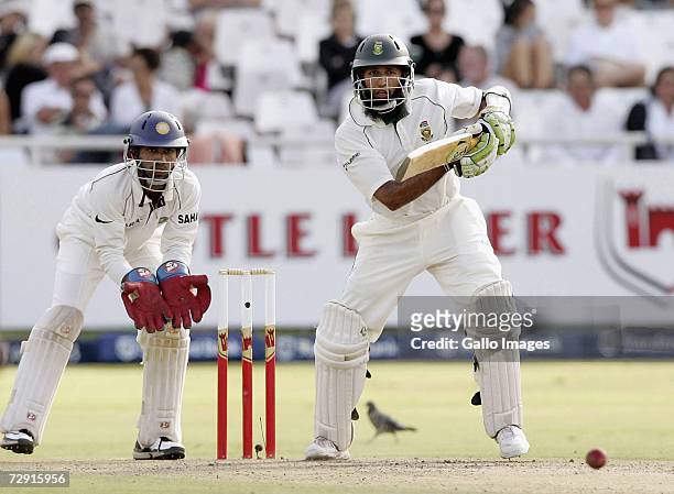 Hashim Amla of South Africa plays a shot as Dinesh Karthik of India looks on during Day Two of the Third test between South Africa and India at the...