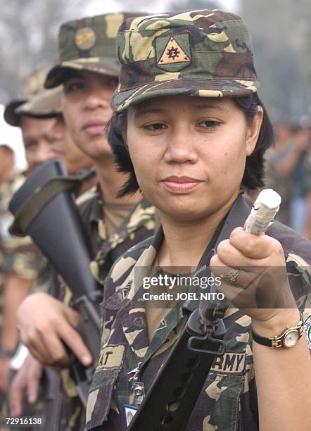 Soldier checks her gun muzzle after sealing it with a tape at the military headquarters in Manila, 28 december 2006. The government has ordered all...