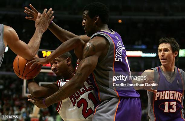 Chris Duhon of the Chicago Bulls attempts to pas the ball against Amare Stoudemire and Steve Nash of the Phoenix Suns January 2, 2007 at the United...