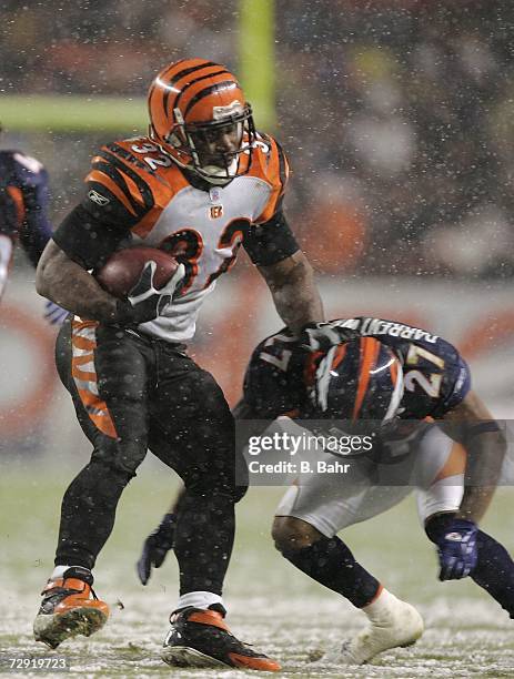 Half back Rudi Johnson of the Cincinnati Bengals fends of cornerback Darrent Williams of the Denver Broncos on December 24, 2006 at Invesco Field at...