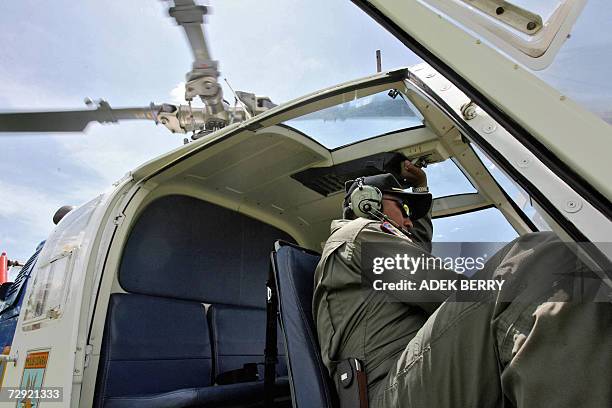 An Indonesian pilot starts his helicopter as search and rescue teams are ongoing in their search for the missing Adam air plane in Polewali, 04...
