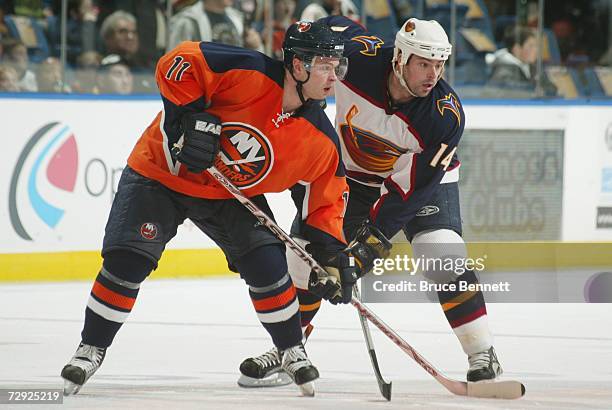 Andy Hilbert of the New York Islanders and Jon Sim of the Atlanta Thrashers gets set on a face off during the NHL game on December 16, 2006 at the...