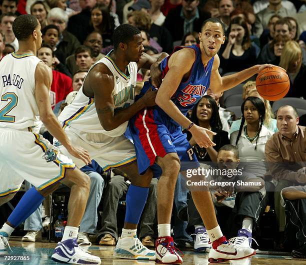 Tayshaun Prince of the Detroit Pistons looks for a open teammate around the defense of Jannero Pargo and Desmond Mason of the New Orleans/Oklahoma...