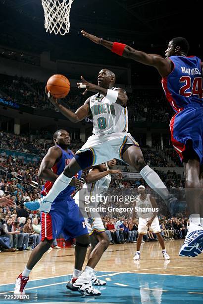 Bobby Jackson of the New Orleans/Oklahoma City Hornets gets a shot off between Antonio McDyess and Jason Maxiell of the Detroit Pistons on January 4,...