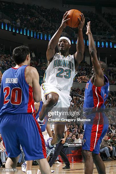 Devin Brown of the New Orleans/Oklahoma City Hornets tries to get to the basket between Carlos Delfino and Ronald Dupree of the Detroit Pistons on...