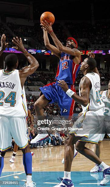 Richard Hamilton of the Detroit Pistons gets to the basket between Desmond Mason and Rasual Butler of the New Orleans/Oklahoma City Hornets on...