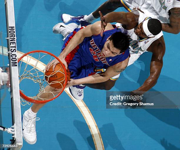 Carlos Delfino of the Detroit Pistons tries to get a shot off past Devin Brown of the New Orleans/Oklahoma City Hornets on January 4, 2007 at the...
