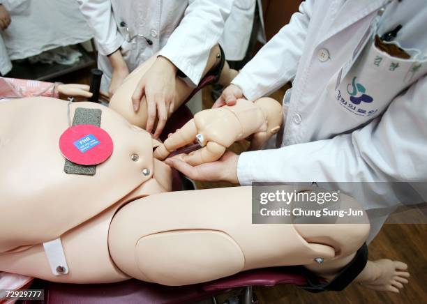 Medical students practice delivering babies with a robot at an obstetrician class of KyungHee university medical center on January 5, 2007 in Seoul,...