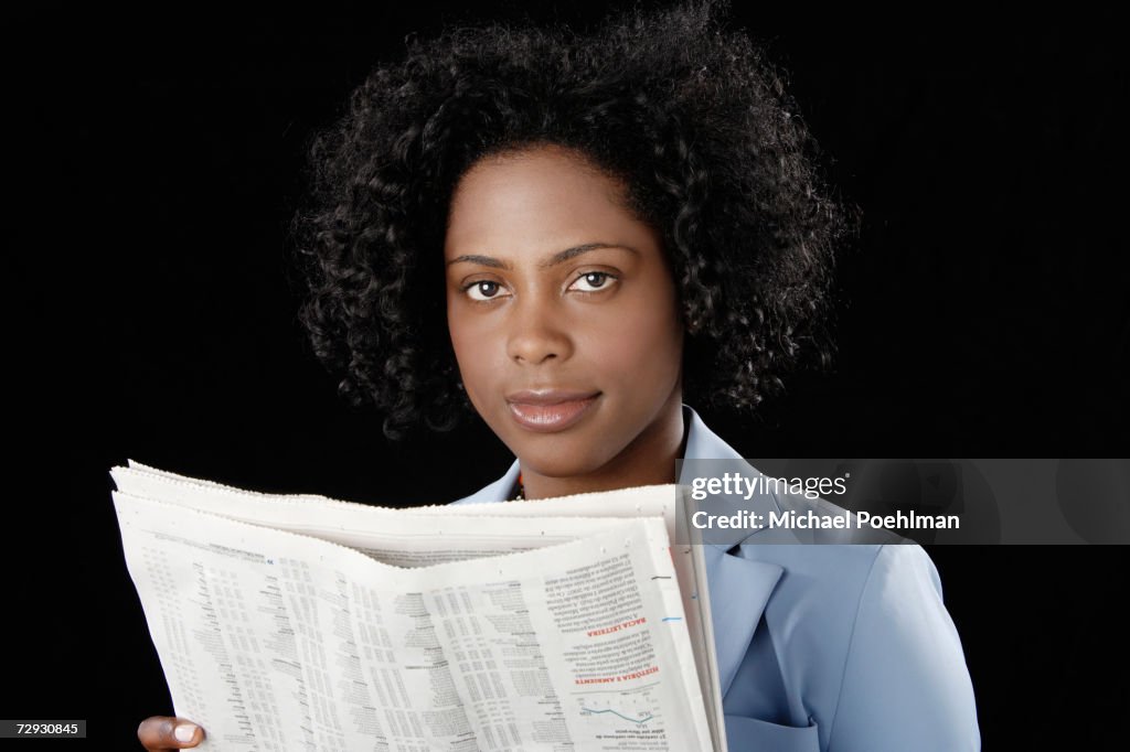 Young woman holding newspaper, portrait