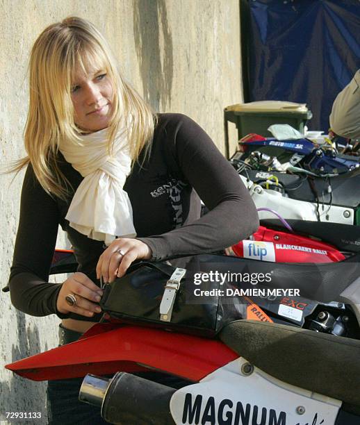 Dakar's youngest competitor, France's rider Anne-Charlotte Tilliette , aged 20, checks her motorbike, 05 January 2007 in Lisbon. She will ride with...