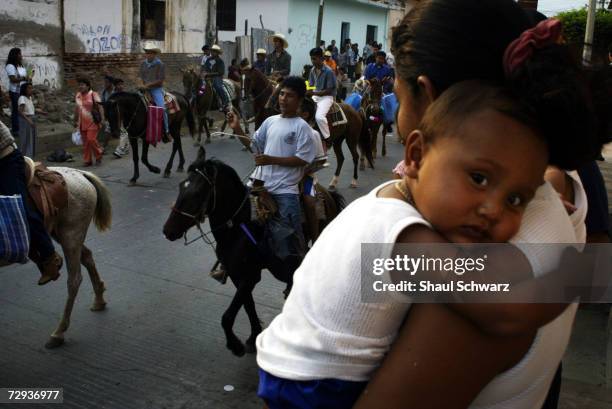 People gather to watch the parade for the Regada Ceremony in Juchitan, Mexico, June 5, 2003. Whether it is a religious ceremony or an Indian...