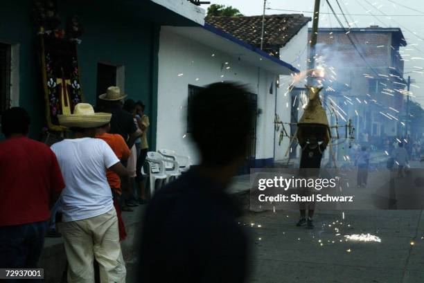 People gather to watch the parade for the Regada Ceremony in Juchitan, Mexico, June 5, 2003. Whether it is a religious ceremony or an Indian...