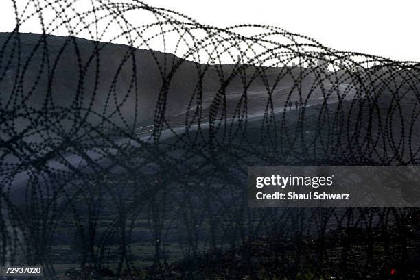 The city of Kalandia is seen through a barbed wire fence that separates the Palestinian city from Israel, April 13, 2003. With Gaza already being...