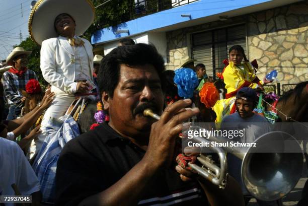 Man blows a trumpet during the parade at the Regada Ceremony in Juchitan, Mexico, June 5, 2003. Whether it is a religious ceremony or an Indian...