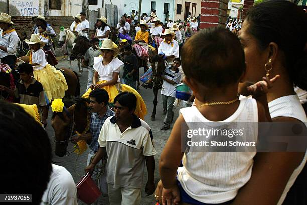 People gather to watch the parade for the Regada Ceremony in Juchitan, Mexico, June 5, 2003. Whether it is a religious ceremony or an Indian...