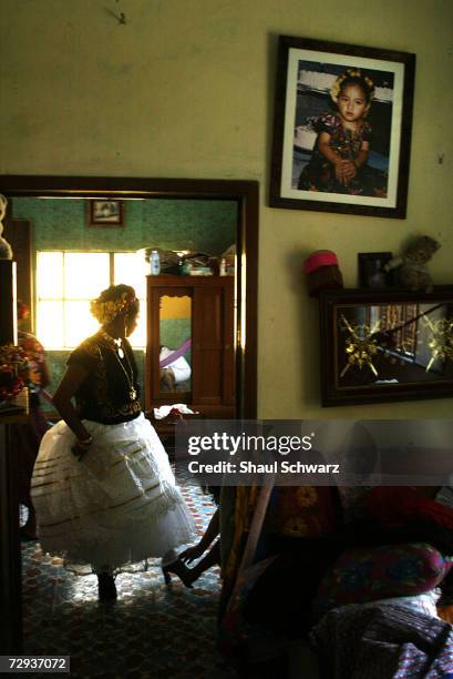 Twenty-three year old queen Arelsely gets help perfecting every detail before leaving her house in Juchitan, Mexico, June 5, 2003. Whether it is a...