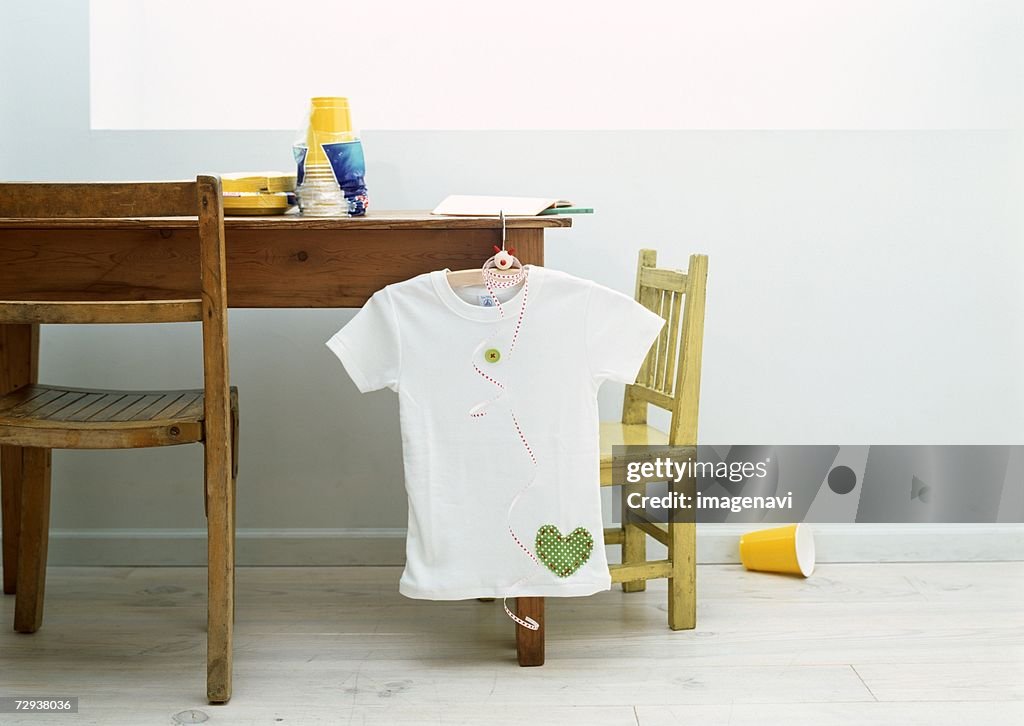 Appliqued t-shirt hanging on desk
