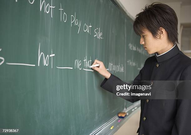 student writing on chalkboard - 日本人　英語 ストックフォトと画像