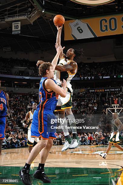 Chris Wilcox of the Seattle SuperSonics goes to the basket over the defense of David Lee of the New York Knicks on January 5, 2007 at the Key Arena...