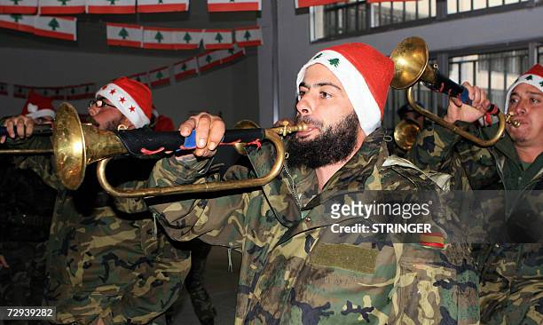 Spanish UN soldiers, wearing Christmas hats decorated with Lebanon's symbol the cedar,blow their trumpets during an Epiphany celebration 05 January...