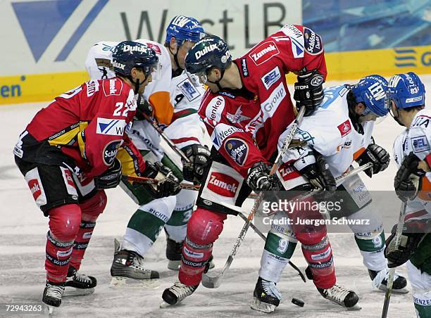 Dusseldorf's Thomas Joerg and Charlie Stephens fight for the puck with Augsburg's Torsten Fendt and Yanick Dube during the DEL Bundesliga match...