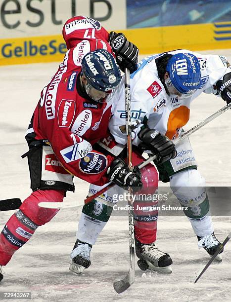 Charlie Stephens of Duesseldorf and Augsburg's Yanick Dube fight for the puck during the DEL Bundesliga match between DEG Metro Stars and Augsburger...