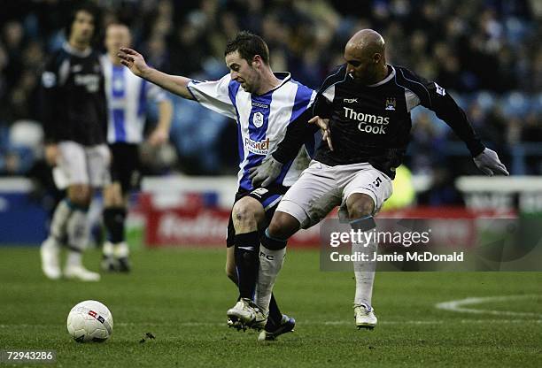 Ousmane Dabo of Manchester City battles with Steven MacLean of Sheffield Wednesday during the FA Cup sponsored by E.ON Third Round match between...