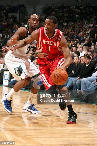 Trenton Hassel of the Minnesota Timberwolves tries to stop Tracy McGrady of the Houston Rockets on January 7, 2007 at the Target Center in...