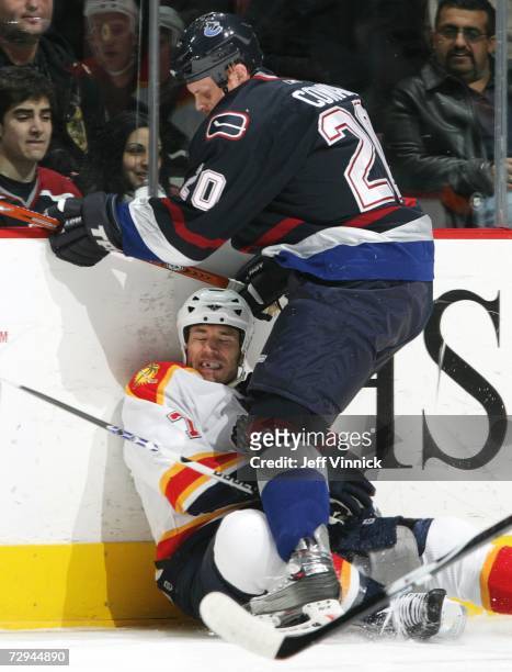 Jeff Cowan of the Vancouver Canucks checks Steve Montador of the Florida Panthers into the ice during their NHL game January 7, 2007 at General...