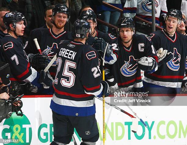 Josh Green receives congratulations from Markus Naslund of the Vancouver Canucks as he skates to the bench following a goal against the Florida...