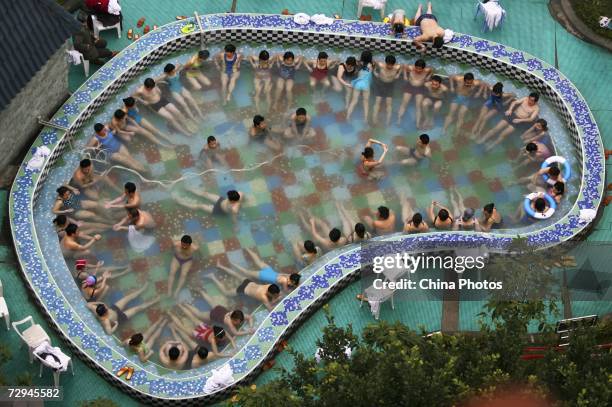 Tourists enjoy a therapy spa in a hot spring resort, home to "Doctor Fish" on January 7, 2007 in Chongqing Municipality, China. Doctor fish are...