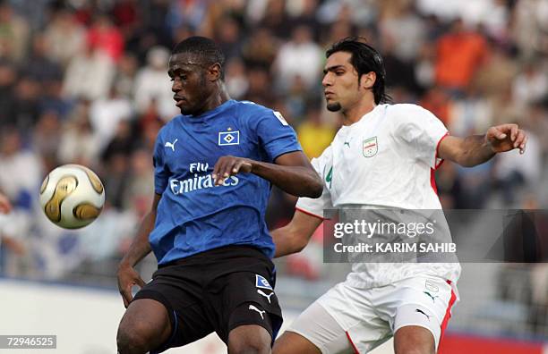 Dubai, UNITED ARAB EMIRATES: Iran's national football team player Amir Hossen Sadeghi figths for the ball with Hamburg's Ivorian striker Boubacar...