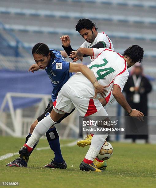 Dubai, UNITED ARAB EMIRATES: Iran's national football team player Amir Hossen Sadeghi and an unidentified teammate fight for the ball with Hamburg's...