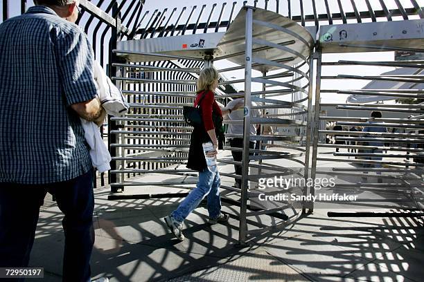 Pedestrians head through turnstiles into Mexico from the United States January 8, 2007 in San Ysidro, California. Beginning on January 23rd, United...