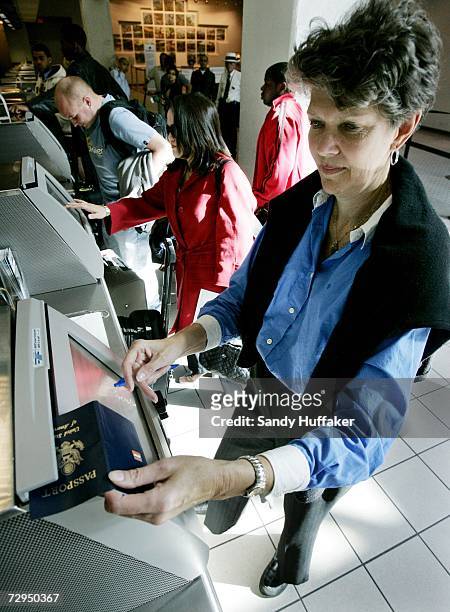 Mary Jane Steen swipes a passport at a check-in kiosk at San Diego International Airport January 8, 2006 in San Diego, California. Beginning on...