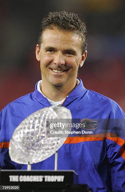 Head coach Urban Meyer of the Florida Gators smile while the BCS Championship trophy awaits him in the forground after defeating the Ohio State...