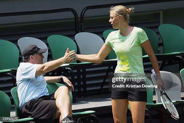 Maria Sharapova of Russia recieves a high five from her coach and father Yuri Sharapova during a practice session at Rod Laver Arena ahead of the...