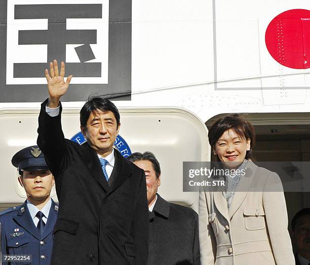 Japanese Prime Minister Shinzo Abe , accompanied by his wife Akie , waves as he leaves to Europe at the Tokyo International Airport for a five day...