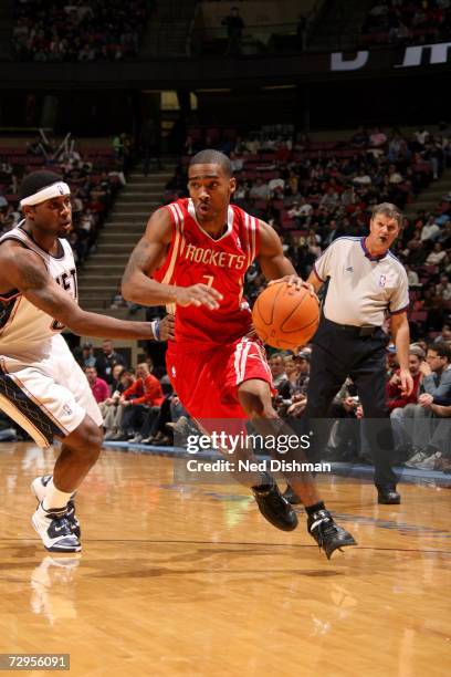 Luther Head of the Houston Rockets drives around Hassan Adams of the New Jersey Nets on December 27, 2006 at the Continental Airlines Arena in East...