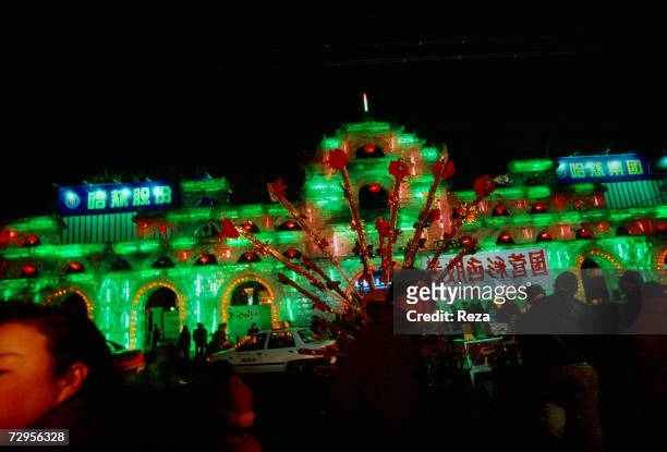 Visitors enjoy a walk in the middle of illuminated ice sculptures in Sun Island Park during the Ice and Snow Festival celebrating Chinese New Year on...