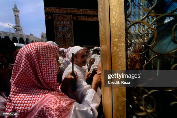 Guard tries to control the flow of worshippers around the Maqam Ibrahim, next to the Kaaba, Islam's most sacred sanctuary and pilgrimage shrine, in...