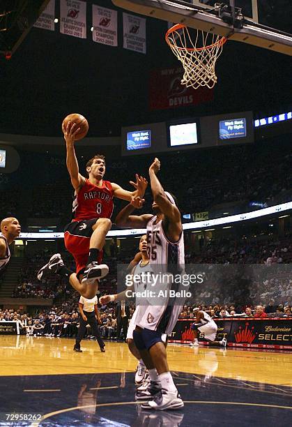 Jose Calderon of the Toronto Raptors goes to the basket as Jason Collins at the Continental Airlines Arena on January 9, 2007 in East Rutherford, New...