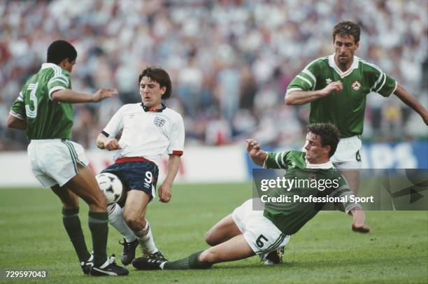 English footballer Peter Beardsley is tackled for the ball by Republic of Ireland players Chris Hughton and Kevin Moran as Mick McCarthy runs to...