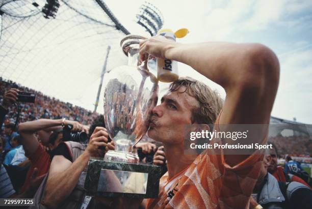 Dutch footballer Adri van Tiggelen kisses the UEFA European Championship trophy in celebration after Netherlands beat the Soviet Union 2-0 to become...