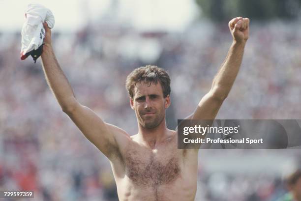 Republic of Ireland centre-back Mick McCarthy, holding an England shirt, raises both arms in the air in celebration after the Republic of Ireland...