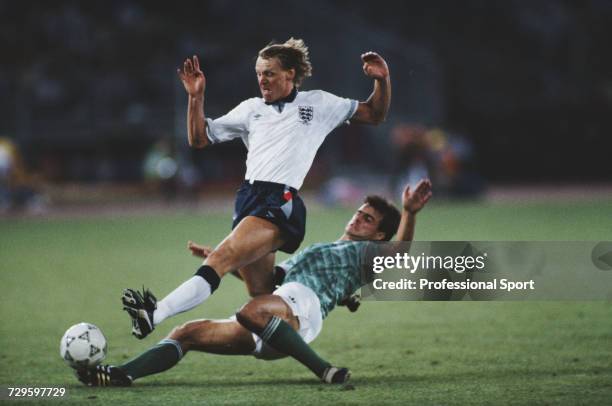 English footballer Stuart Pearce is tackled by West Germany player Thomas Berthold during the semi final match between West Germany and England in...