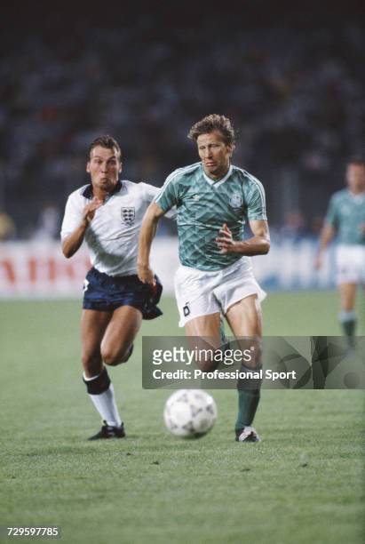 English footballer David Platt attempts to catch and stop West Germany player Guido Buchwald during the semi final match between West Germany and...